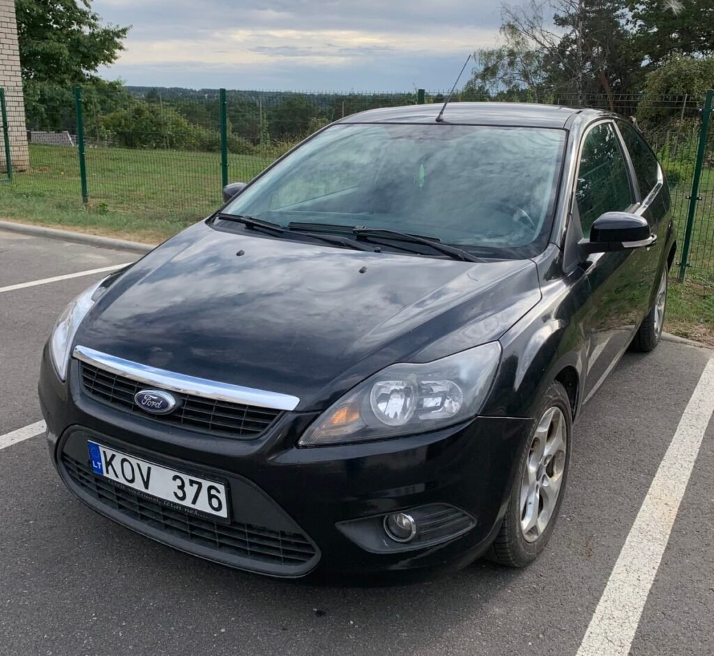 Juodas Ford Focus hečbekas automobilių aikštelėje. Naudotų automobilių supirkimas Pakruojyje, AutoDylas.
