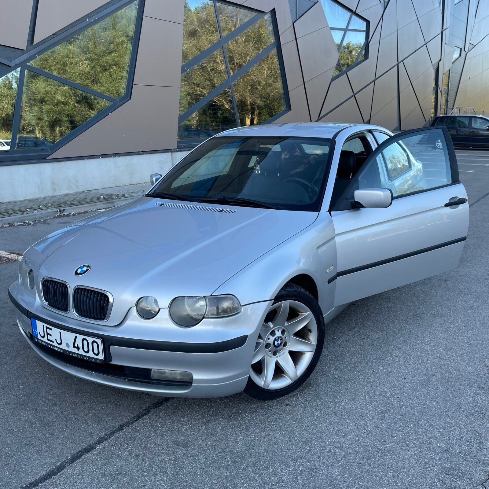 Automobilių supirkimas Telšiuose: sidabrinis BMW 3 serijos (Compact) automobilis atidarytomis durimis, kurį brangiai superka įmonė AutoDylas.