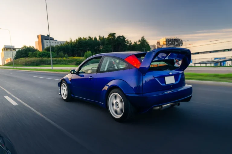Mėlynas sportinis Ford Focus važiuojantis miesto gatve - auto supirkimas