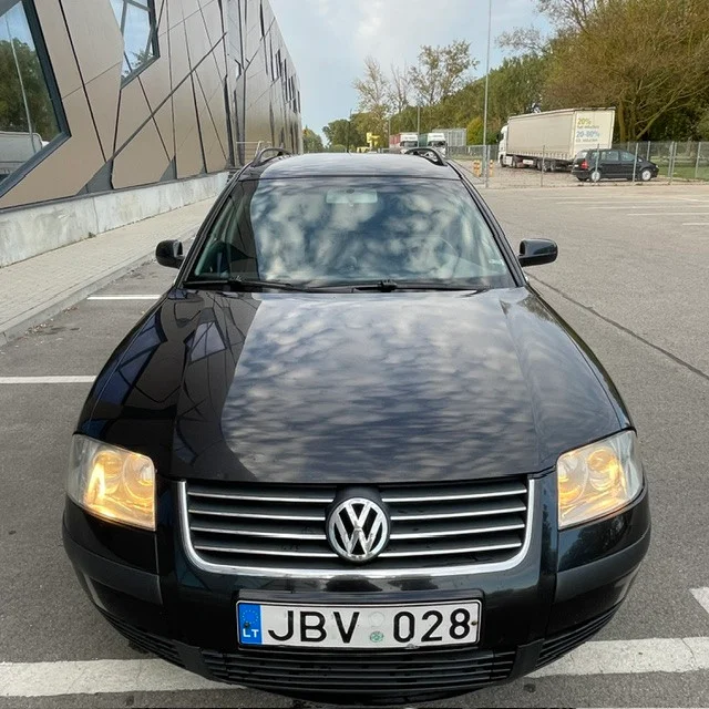 Tvarkingas juodas Volkswagen automobilis asfaltuotoje miesto stovėjimo aikštelėje - greitas automobilių supirkimas ukmergėje.