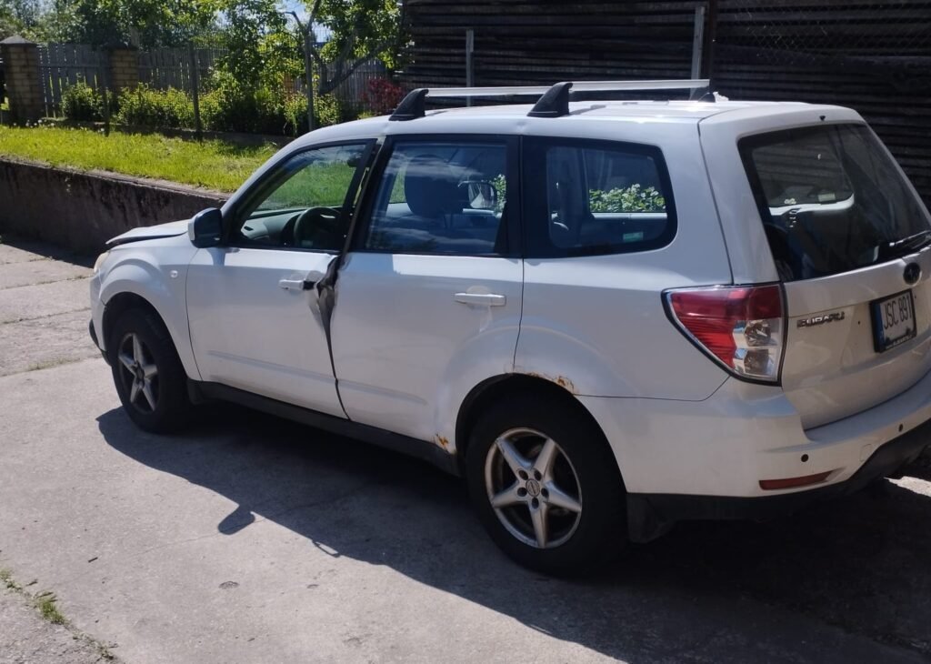 Daužtas baltas Subaru automobilis su pažeistomis durelėmis – greitas automobilių supirkimas Vilniuje.
