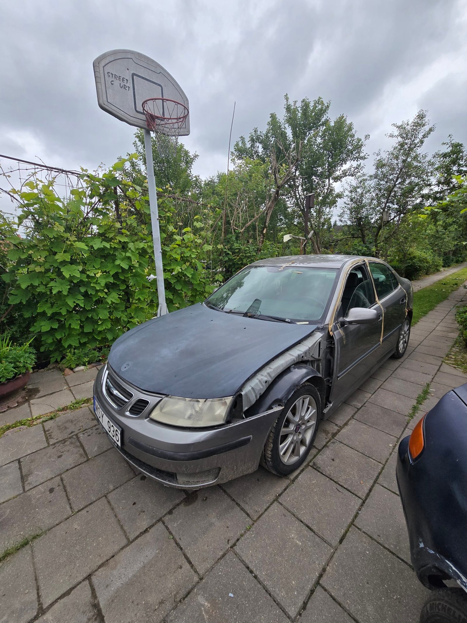 Pilkas ilgai stovėjęs automobilis su kėbulo defektais Jonavos sodų kieme, kurį greitai nupirkti ir išvežti gali „Autodylas“ komanda. Automobilių supirkimas Jonavoje
