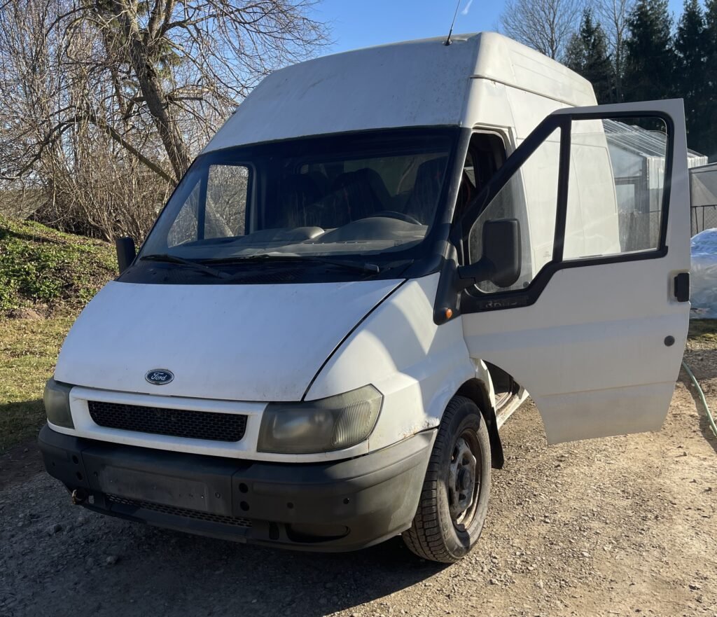 Baltas, nenaudojamas Ford furgonas atidarytomis durimis kieme – greitas mikroautobusų ir autobusiukų supirkimas.